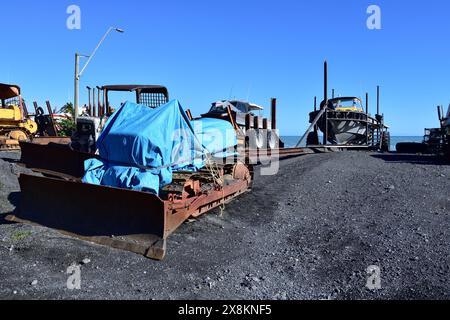 Pirinoa, Nouvelle-Zélande - 05-05-24:excavatrice Vinatge sous une bâche bleue et remorque de bateau à voile Banque D'Images