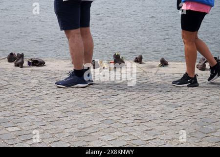 Touristes passant les Chaussures sur la rive du Danube commentant les Juifs qui ont été tués et persécutés à Budapest, en Hongrie, pendant la seconde Guerre mondiale Banque D'Images