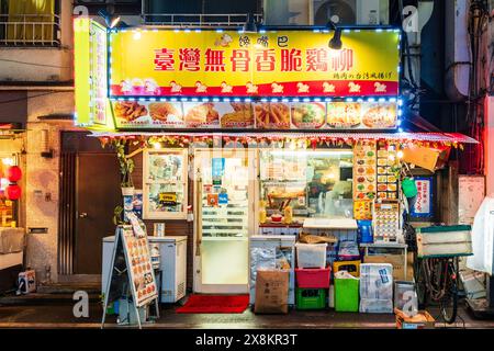 Façade extérieure du restaurant chinois à Otsuka, Tokyo. Porte d'entrée avec fenêtres avant avec menus. Sur le trottoir beaucoup de caisses et de boîtes. Nuit. Banque D'Images