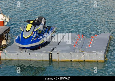 Un jet ski Yamaha bleu et gris est assis sur un radeau dans l'eau, port touristique de San Vincenzo, Toscane, Italie Banque D'Images