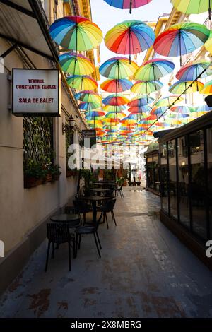 Bucarest, Roumanie. 23 mai 2024. Plafond de parasols multicolores dans une rue étroite du centre-ville Banque D'Images