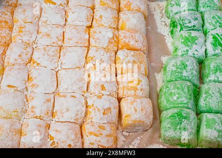 Mochi de dessert sucré japonais fabriqué à partir de pâte de riz jaune et vert sur un étal de marché de nourriture de rue en Asie. Banque D'Images
