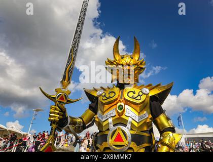 Londres, Royaume-Uni. 26 mai 2024. Un cosplayer en tenue de « Iron Warrior » pose dans son lourd costume doré. Un participant pose dans une tenue comme Stolas de 'helluva Boss'. MCM Comic Con à Excel London est occupé le dernier jour. Cosplayers, fans d'anime, de bandes dessinées, de jeux et de films se réunissent pour ce grand événement de trois jours du 24-26 au 30 mai. Crédit : Imageplotter/Alamy Live News Banque D'Images