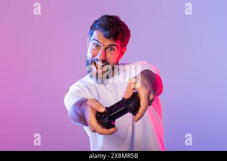 Homme tenant la manette de jeu vidéo dans la lumière néon Banque D'Images