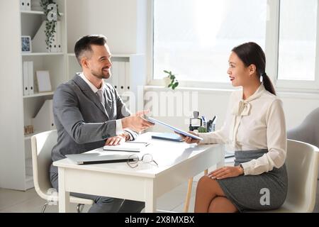 Femme candidat asiatique avec gestionnaire des ressources humaines à l'entrevue d'emploi dans le bureau Banque D'Images
