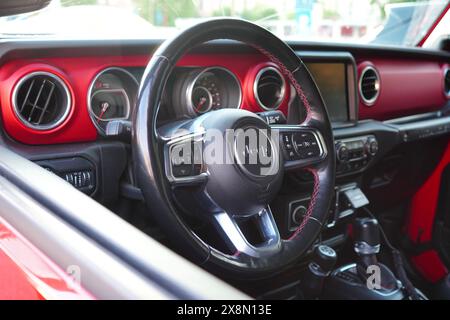 Bucarest, Roumanie - 24 mai 2024 : gros plan sur le volant et le tableau de bord de Rubicon Jeep Wrangler voiture rouge hors route Banque D'Images