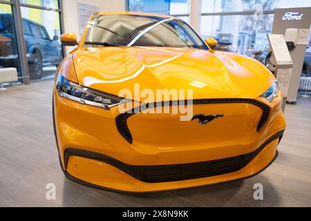 Gros plan de jaune Ford Mustang Mach-E , ev Ford Motor Company dans la salle d'exposition, tendances dans l'utilisation EV dans l'Europe contemporaine, avancées technologiques dans aut Banque D'Images