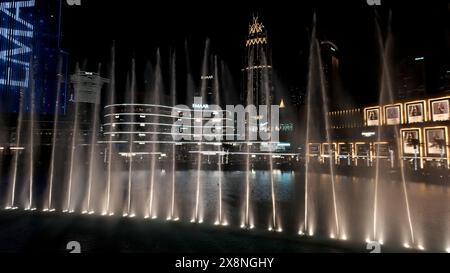 Dubaï - Émirats arabes Unis, 17 février 2023 : spectacle de fontaines colorées la nuit. Action. Belle rue de la ville avec éclairage lumineux. Banque D'Images