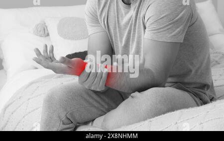 Homme souffrant de douleur à la main sur le lit, gros plan. Effet noir et blanc. Conception de bannière Banque D'Images