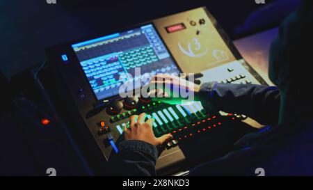 Commande de console d'éclairage. Support. L'homme déplace les joysticks sur le panneau de commande de lumière et de son dans le théâtre. Console de contrôle moderne du son et de la lumière dans le théâtre Banque D'Images