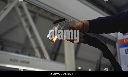 Le laser élimine la rouille sur le métal. Support. Pistolet à main avec laser élimine la rouille sur le métal. Laser avec faisceau élimine la rouille métallique sur les pièces Banque D'Images