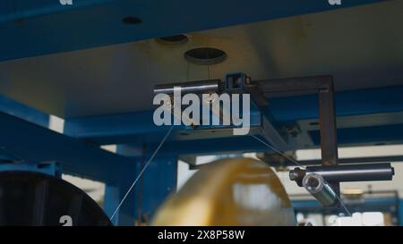 Bobines rotatives avec des fils en usine. Créatif. Distribution et bobinage de fils sur bobines à l'entreprise métallurgique. Enroulement de lignes polymères sur Banque D'Images
