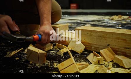 Travaux de menuiserie, sculpture de bloc de bois. Support. Utilisation d'un burin pour le traitement des barres de bois lors de l'assemblage des décorations de scène. Banque D'Images