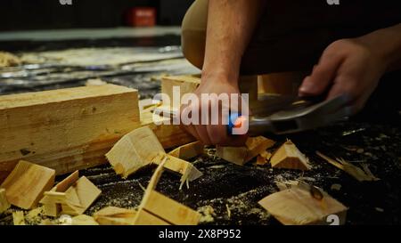 Travaux de menuiserie, sculpture de bloc de bois. Support. Utilisation d'un burin pour le traitement des barres de bois lors de l'assemblage des décorations de scène. Banque D'Images