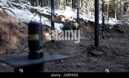 Procédé de renforcement du sol avec des pieux sur le chantier de construction. Agrafe. Ouvrier aux ouvrages de renforcement des sols. Banque D'Images