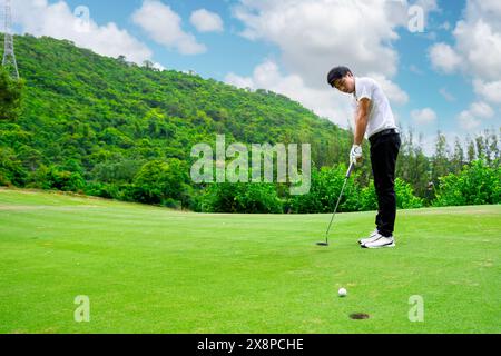 Golfeur utilise un putter pour mettre une balle de golf sur le green. club de golf sportif Banque D'Images