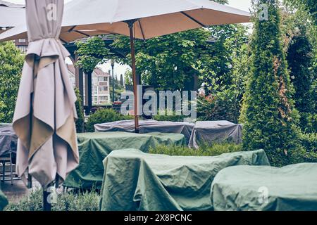 Les cafés d'été sont couverts de couvertures dans un café extérieur vide. Les tables et les chaises sont fermées la nuit, à l'extérieur. Il n'y a pas de visiteurs. Avec espace à copier. Photo de haute qualité Banque D'Images