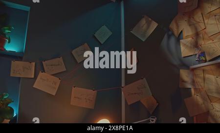 Notes et fils postés. Film de stock. Intérieur de détective avec notes et fil. Notes accrochées sur du fil rouge partout dans le bureau Banque D'Images