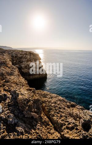 Le soleil se lève sur la côte sud des falaises rocheuses et de l'eau calme sur l'île de Minorque, îles Baléares, Espagne. Concept touristique espagnol Banque D'Images