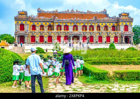 Un groupe d'élèves vietnamiens du primaire ont reçu l'instruction de leur professeur de famille de visiter la citadelle interdite à Hue, au Vietnam Banque D'Images