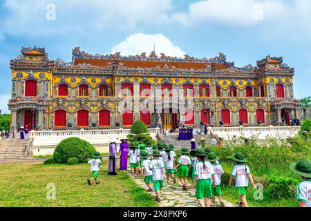 Un groupe d'élèves vietnamiens du primaire ont reçu l'instruction de leur professeur de famille de visiter la citadelle interdite à Hue, au Vietnam Banque D'Images