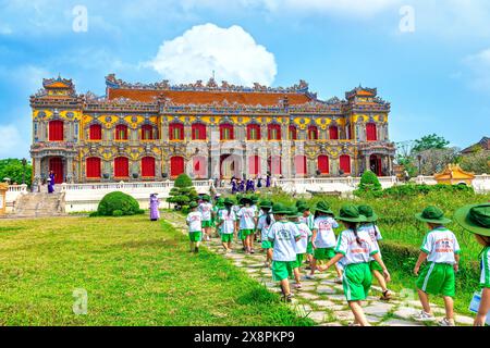 Un groupe d'élèves vietnamiens du primaire ont reçu l'instruction de leur professeur de famille de visiter la citadelle interdite à Hue, au Vietnam Banque D'Images