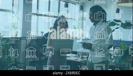 Image de plusieurs icônes au-dessus de divers collègues debout et discutant des rapports au bureau Banque D'Images