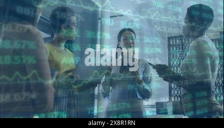 Image d'une table de négociation sur diverses collègues féminines debout et discutant au bureau Banque D'Images