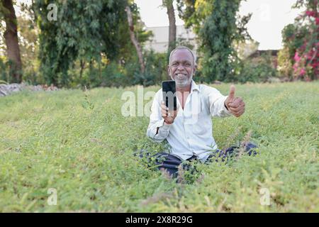 Élevage de pois chiches indiens, fermier indien heureux tenant le téléphone portable dans les mains, pauvre fermier heureux Banque D'Images