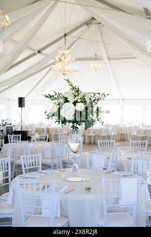 Tente de réception de mariage avec lustres et centres de table floraux blancs Banque D'Images