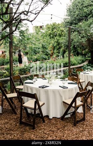 Configuration de la réception avec jardin extérieur avec tables rondes et chaises en bois Banque D'Images