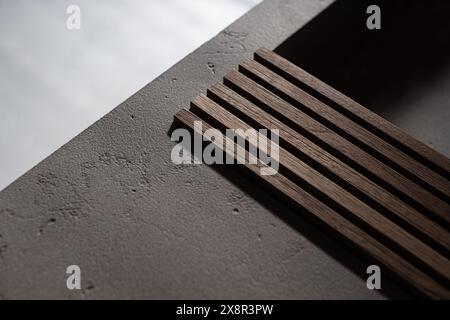 Lattes en bois sur une surface en béton avec un éclairage doux Banque D'Images