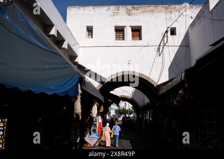 Une vue d'une arche dans le quartier Habous de Casablanca, Maroc, le 7 octobre 2023, avec des gens marchant et des étals de marché de chaque côté. Cette zone Banque D'Images