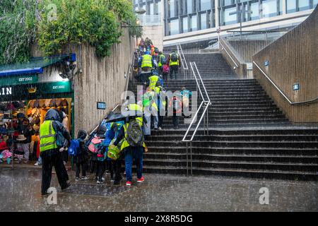 Les touristes attendent qu'un passage souterrain inondé se dégage après une tempête de pluie près de la station de métro Tower Hill à Londres. Banque D'Images