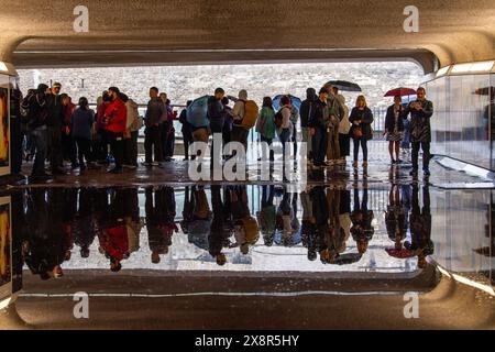 Les touristes attendent qu'un passage souterrain inondé se dégage après une tempête de pluie près de la station de métro Tower Hill à Londres. Banque D'Images