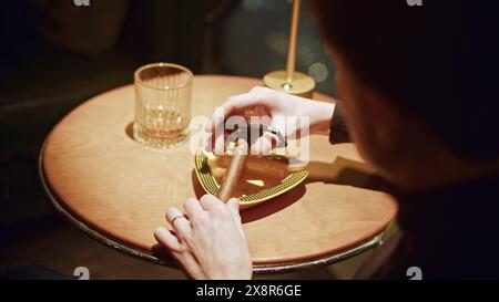 Gros plan d'un homme coupant le cigare. Support. L'homme coupe le bord du Viagra pour fumer. Couteau de coupe de cigare professionnel dans le club cubain Banque D'Images