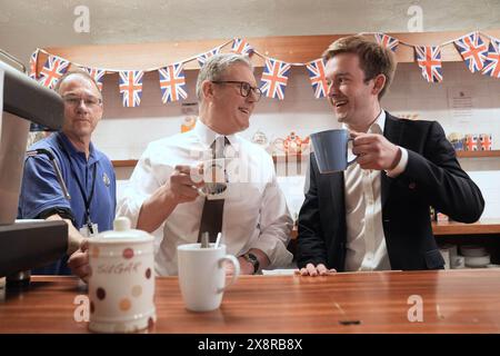 Le chef du Parti travailliste Sir Keir Starmer prend un verre avec East Worthing et le candidat parlementaire de Shoreham Tom Rutland (à droite), après avoir prononcé son premier discours à la salle paroissiale de Lancing dans le Sussex de l'Ouest, alors qu'il était sur la piste de la campagne électorale générale. Date de la photo : lundi 27 mai 2024. Banque D'Images