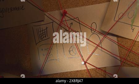 Éclairage rapproché des notes à bord. Film de stock. Lampe de poche illumine des notes secrètes à bord avec des fils. Les fils rouges se croisent à bord avec Banque D'Images