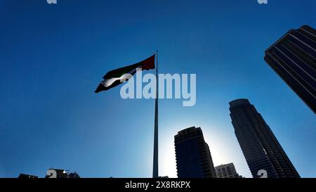 Vue en angle bas d'un drapeau agitant contre le ciel bleu. Action. Dubaï, Émirats arabes Unis, architecture et agitant le drapeau. Banque D'Images