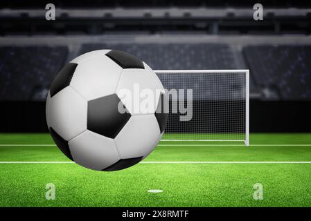 Ballon classique noir et blanc sur un terrain de football avec un but et représente le public en arrière-plan, capturant l'essence du jeu Banque D'Images