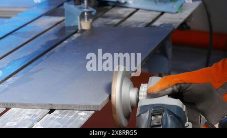 Gros plan d'un travailleur polissant une porte d'armoire dans une usine de meubles. Créatif. Fond industriel avec un charpentier au travail. Banque D'Images