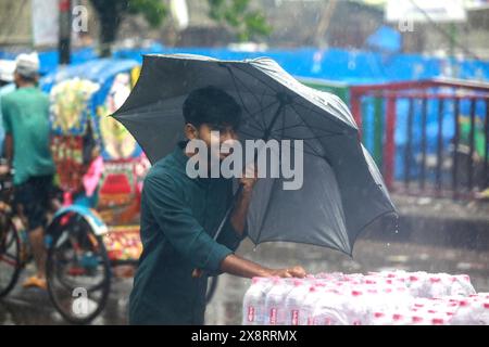 Les navetteurs souffrent des fortes pluies causées par le cyclone « Remal » à Dhaka, au Bangladesh. 27 mai 2024. Les gens de bureau et les personnes à faible revenu dans la capitale Dacca font face à des problèmes en raison des précipitations provoquées par le cyclone Remal qui ont commencé tôt le matin lundi. Les précipitations incessantes augmentent parfois alors qu'elles diminuent après un certain temps, ce qui entraîne une incertitude du mouvement des gens. Beaucoup de gens sortent de chez eux pour aller travailler, mais les transports en commun sont insuffisants. Photo de Suvra Kanti Das/ABACAPRESS. COM Credit : Abaca Press/Alamy Live News Banque D'Images