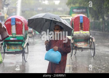 Les navetteurs souffrent des fortes pluies causées par le cyclone « Remal » à Dhaka, au Bangladesh. 27 mai 2024. Les gens de bureau et les personnes à faible revenu dans la capitale Dacca font face à des problèmes en raison des précipitations provoquées par le cyclone Remal qui ont commencé tôt le matin lundi. Les précipitations incessantes augmentent parfois alors qu'elles diminuent après un certain temps, ce qui entraîne une incertitude du mouvement des gens. Beaucoup de gens sortent de chez eux pour aller travailler, mais les transports en commun sont insuffisants. Photo de Suvra Kanti Das/ABACAPRESS. COM Credit : Abaca Press/Alamy Live News Banque D'Images