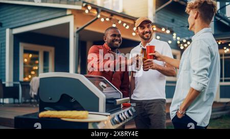 Trois Happy Young Adult Men se sont rassemblés autour d'un barbecue, discutant et racontant des histoires amusantes tout en préparant un steak de bœuf barbecue. Amis passant du temps à l'extérieur, parlant, se relaxant, buvant des bières. Banque D'Images