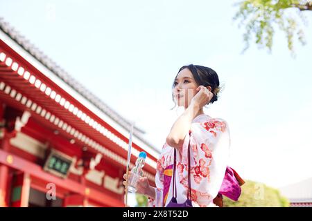 Femme japonaise dans un yukata visitant un temple traditionnel à Tokyo Banque D'Images