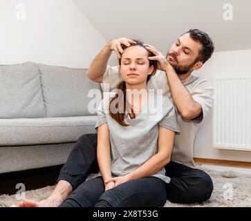 Soins et confort dans la relation familiale. Homme donnant un massage de la tête à la femme Banque D'Images