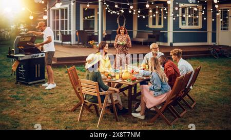 Famille et amis multiethniques divers se réunissant à une table de jardin. Gens cuisiner de la viande sur un grill au feu, préparer de savoureuses salades pour une grande fête de famille avec des parents. Banque D'Images