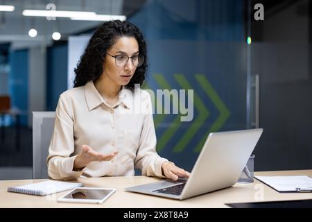 Bouleversée femme latino-américaine déçue sur le lieu de travail à l'intérieur du bureau, femme d'affaires a reçu une erreur de rejet d'e-mail, travailleuse regardant confus à l'écran d'ordinateur portable. Banque D'Images