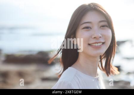 Femme japonaise aux cheveux longs souriant à la caméra Banque D'Images