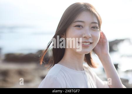 Femme japonaise aux cheveux longs souriant à la caméra Banque D'Images